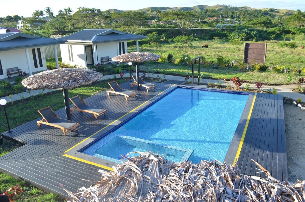 The pool deck with loungers and garden views